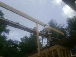 Carpenter setting a ridge beam over a new addition frame — Ice Dam Removal by Roofing Brothers in Mc Alisterville
