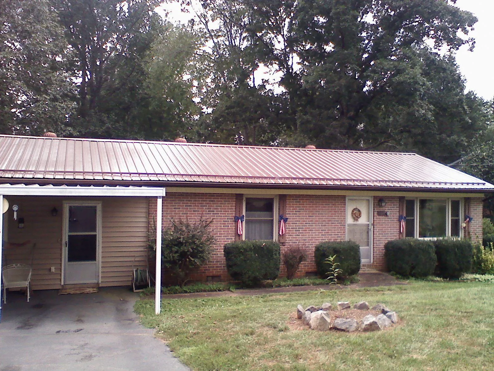 Bronze metal roof and carport on a brick ranch home — Roof Repair work by our crew in Mc Alisterville